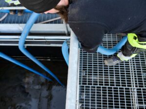 Avloppstekniker som håller i en slang vid tömmning av avloppstank